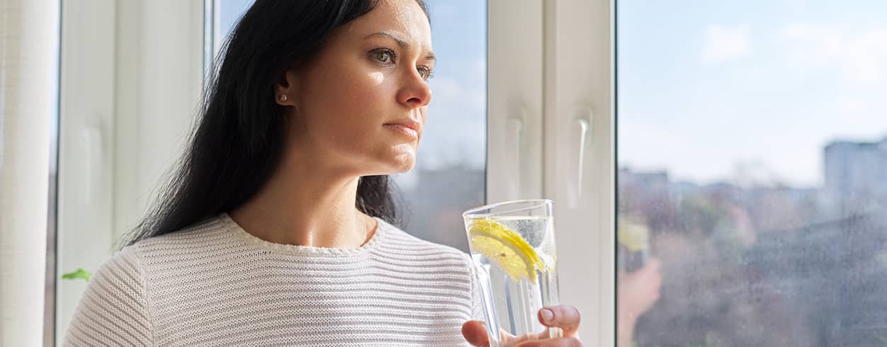 Kobieta trzymająca szklankę wody z cytryną