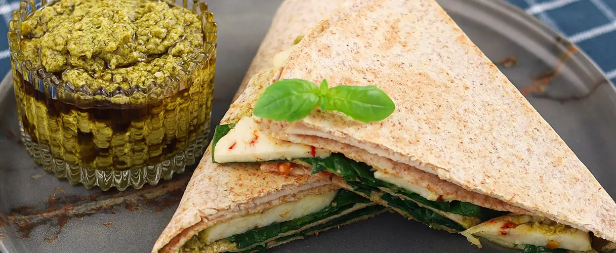 Kieszonka z tortilli z pesto, halloumi, szynką i warzywami