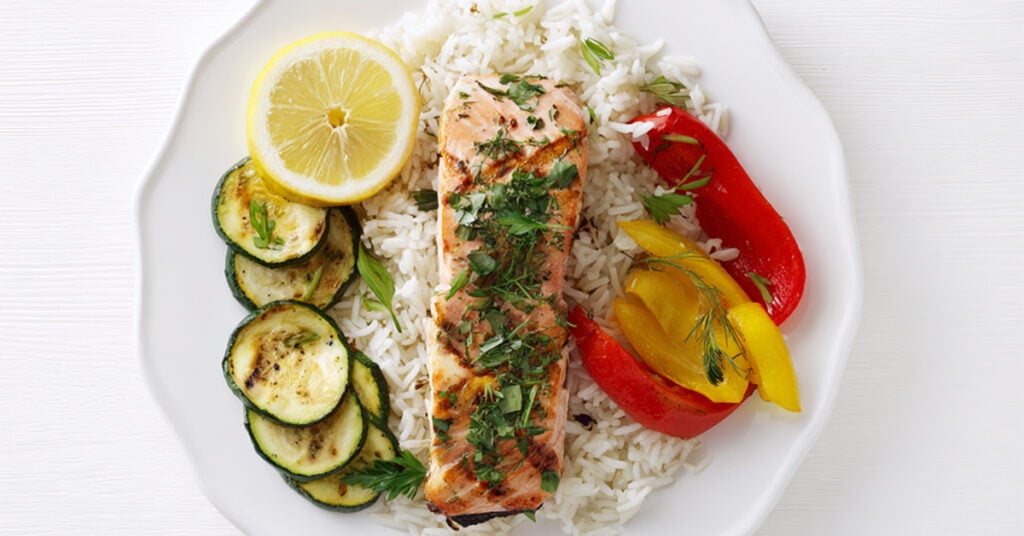Grillowany łosoś z ziołami i cytryną podany z ryżem i cukinią, papryką 